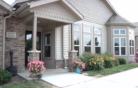 Front exterior view of Vista Pointe II with entrance, windows, and flowering planters.
