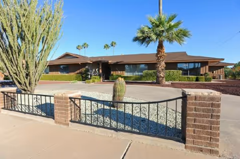 Class Act Assisted Living Home: a single-story building with desert landscaping and palms.