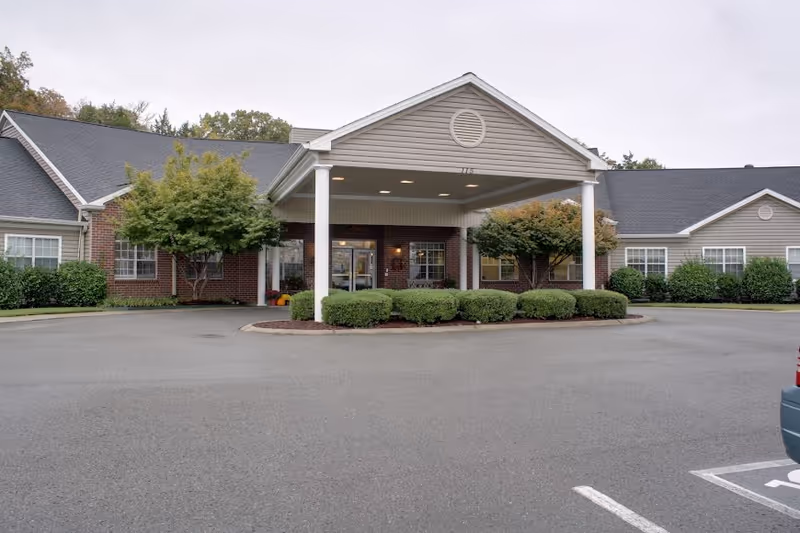 Senior living facility Lincoln Manor exterior with covered entrance and manicured shrubs.