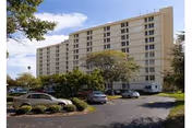 Exterior view of Jefferson Center, a multi-story senior living building with a parking lot.