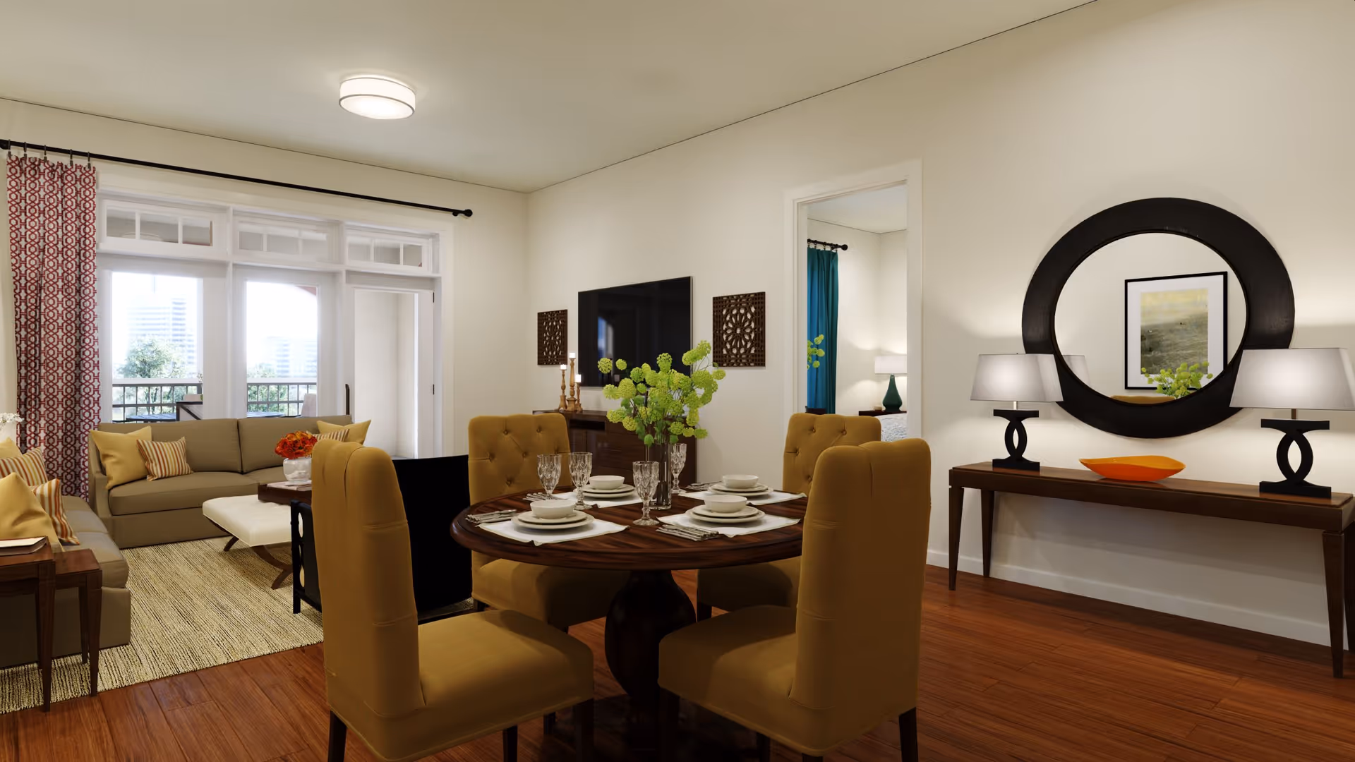Open-plan living and dining area with a set round dining table and upholstered chairs in the foreground, a sofa and TV in the background, and a console table with a round mirror on the wall.