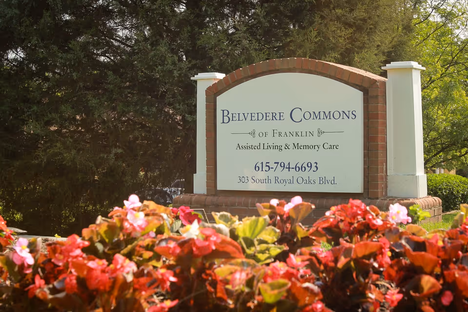 Entrance sign for Belvedere Commons of Franklin assisted living and memory care with flowers in the foreground.