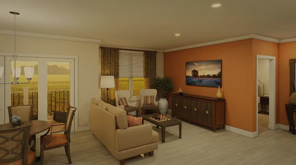 A cozy living room area with a beige sofa, two armchairs, a coffee table with a chessboard, and a wooden cabinet against an orange accent wall with a landscape painting above it. To the left, there is a dining area with a round table and four chairs near glass doors leading outside. The room has light wood flooring and warm lighting.