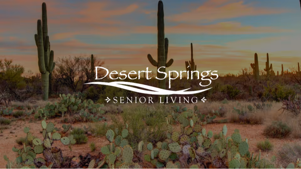 Desert landscape with various cacti and desert plants under a colorful sky at sunset, with the text 'Desert Springs Senior Living' overlaid in the center.