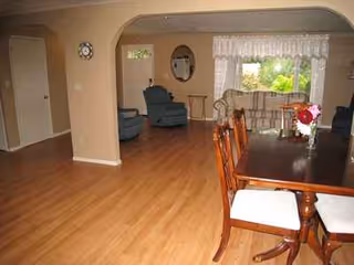 Interior of a senior living dining area with a wooden table and chairs.