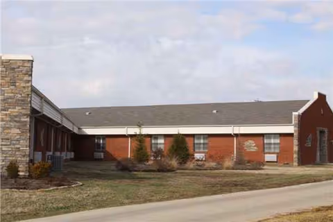 Exterior view of Crowley Ridge Care Center, a single-story brick building with landscaping.