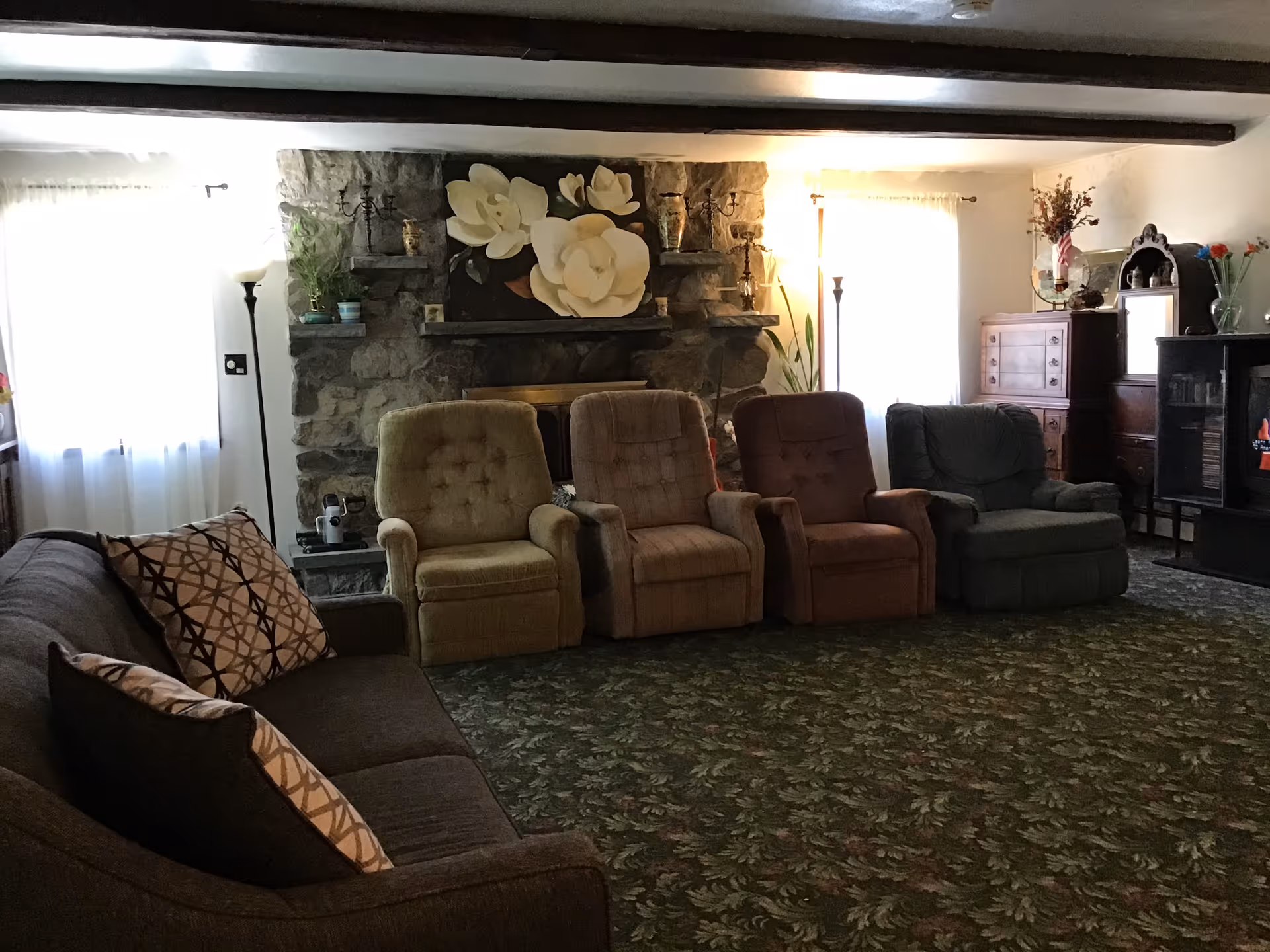 Pine Ridge Adult Care living room with recliners and stone fireplace.