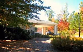 Exterior view of The Harbor at Hickory Hill entrance with a covered driveway and landscaping.