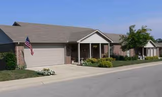 Front view of Mccready Manor, a single-story brick senior living facility with a driveway.