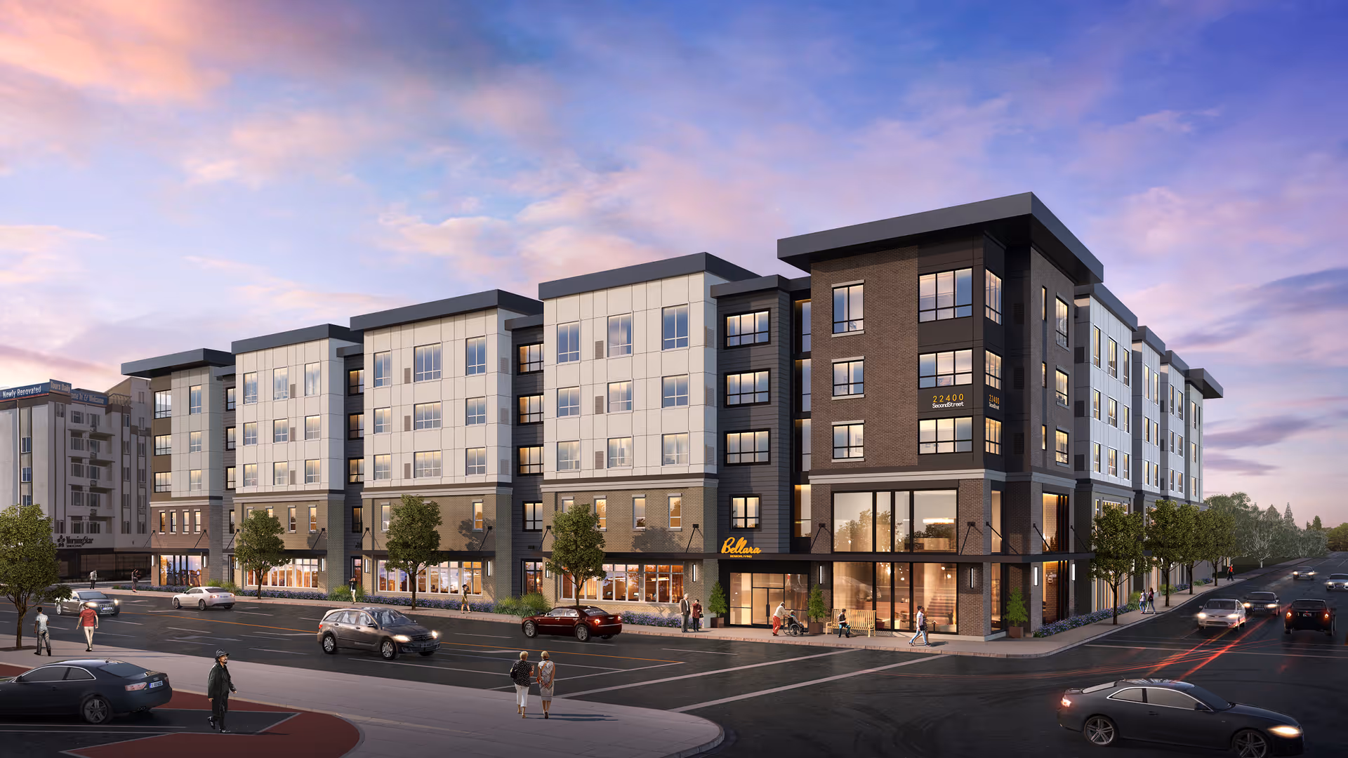 A modern, multi-story Bellara Senior Living building along a tree-lined street with storefronts on the ground floor at dusk.