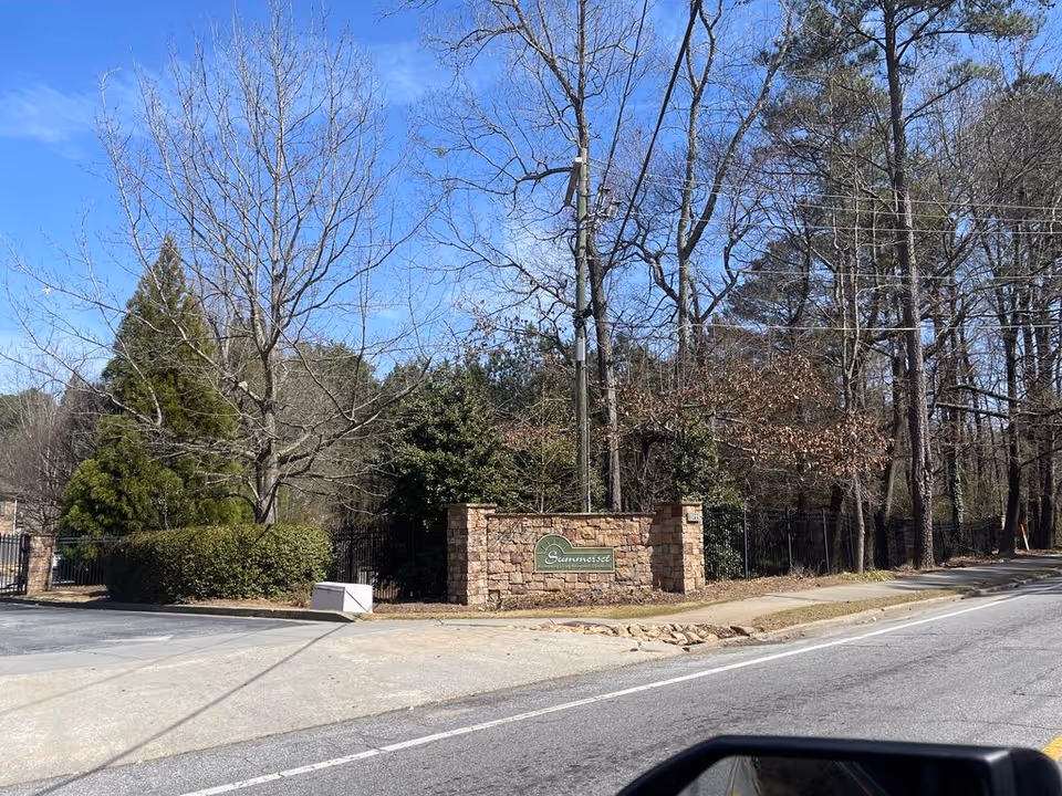 Stone entry sign for Summerset at a tree-lined roadside entrance.