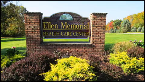 A brick sign reads Ellen Memorial Health Care Center amid landscaped shrubs