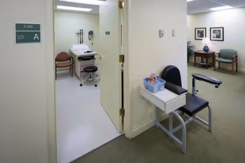 Interior of a senior facility showing an exam bed, medical equipment, and seating.