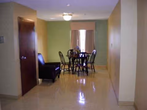 Dining table with chairs and a sofa in a well lit interior living area