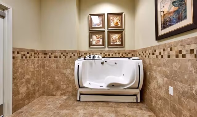 Tiled bathroom featuring a white walk-in bathtub against a wall with framed artwork.