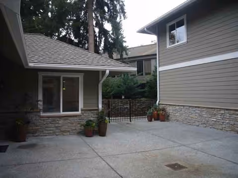 Outdoor courtyard at Abundant Life Lynnwood with buildings and potted plants.