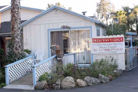 Single-story building with Princess Lodge sign, front entrance, and decorative rocks.