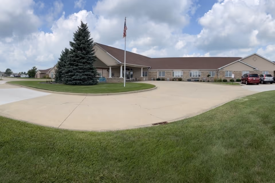 Exterior view of Brookstone Estates of Tuscola, a single-story facility with circular driveway and flagpole.