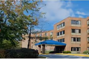 Brick exterior of Pineview Manor Extended Care with blue canopy entrance.