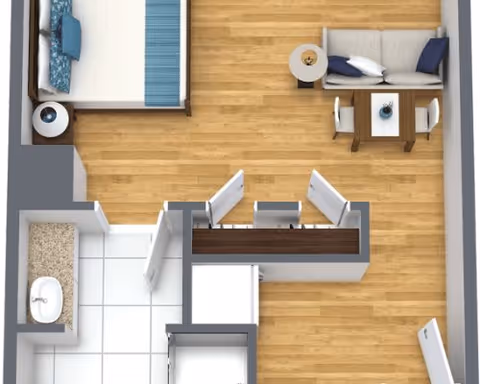 Top-down view of a small apartment floor plan showing a bedroom with a bed and nightstand, a living area with a sofa, coffee table, and dining table with chairs, and a bathroom with a sink and toilet.