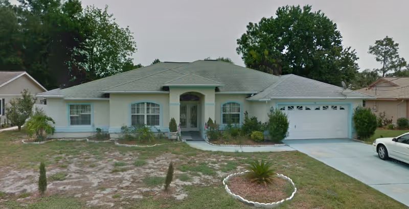 Front exterior of a single-story house with landscaping and a two-car garage.