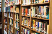 Wooden bookshelves filled with books in a library or reading area.
