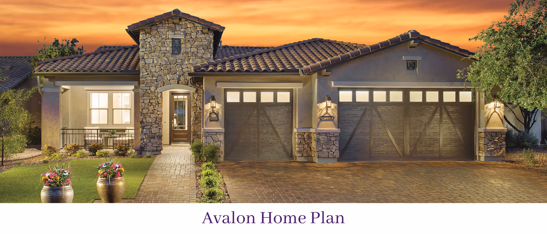 Exterior front view of a single-story house with a stone facade, three garage doors, a tiled roof, and a walkway leading to the front door, set against a sunset sky.