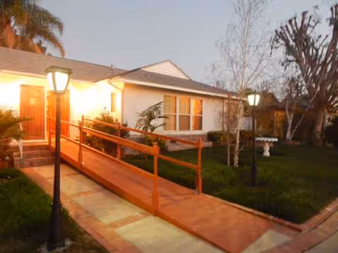 Exterior view of Royal Senior Living with a ramp and lit front walkway.