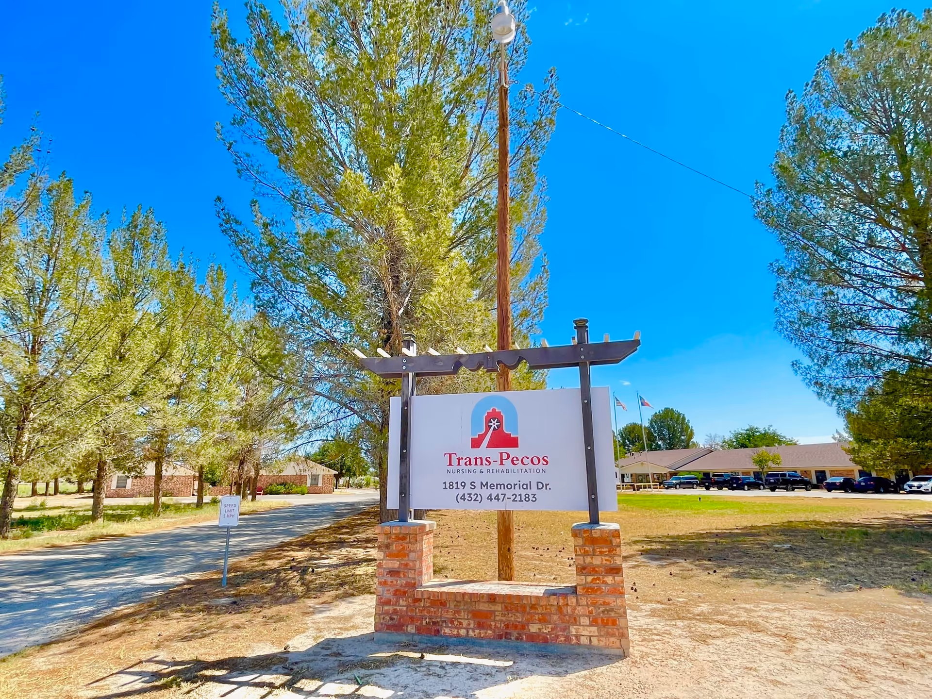Sign for Trans-Pecos Nursing and Rehabilitation facility in a landscaped outdoor area.