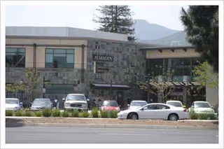Exterior view of Bonhomie I, a modern senior living facility with parked cars.