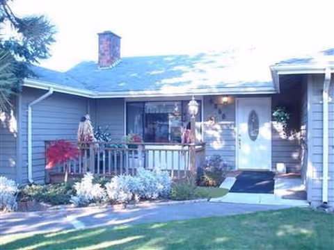 Front exterior of a single-story home with porch and landscaped yard.