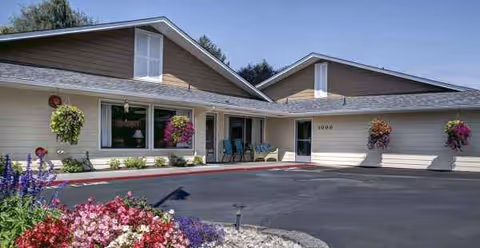 Kamlu Retirement Inn-Vancouver front exterior with a parking lot and hanging flower baskets
