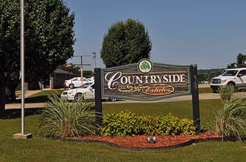 Exterior view of Countryside Estates Nursing sign with landscaping and parked cars nearby.