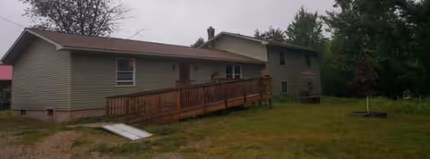 Exterior of a single-story Morgan Assisted Living building with a wooden ramp and grassy yard.