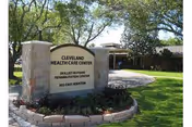 Stone sign reads Cleveland Health Care Center at a landscaped entrance with trees