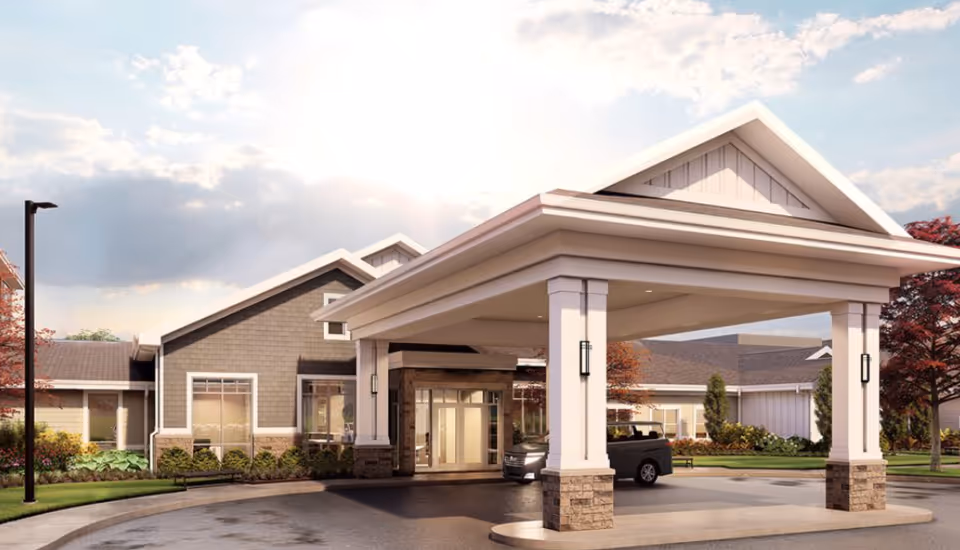 Front view of The Ashford of Beavercreek entrance with a porte-cochere and landscaped driveway.