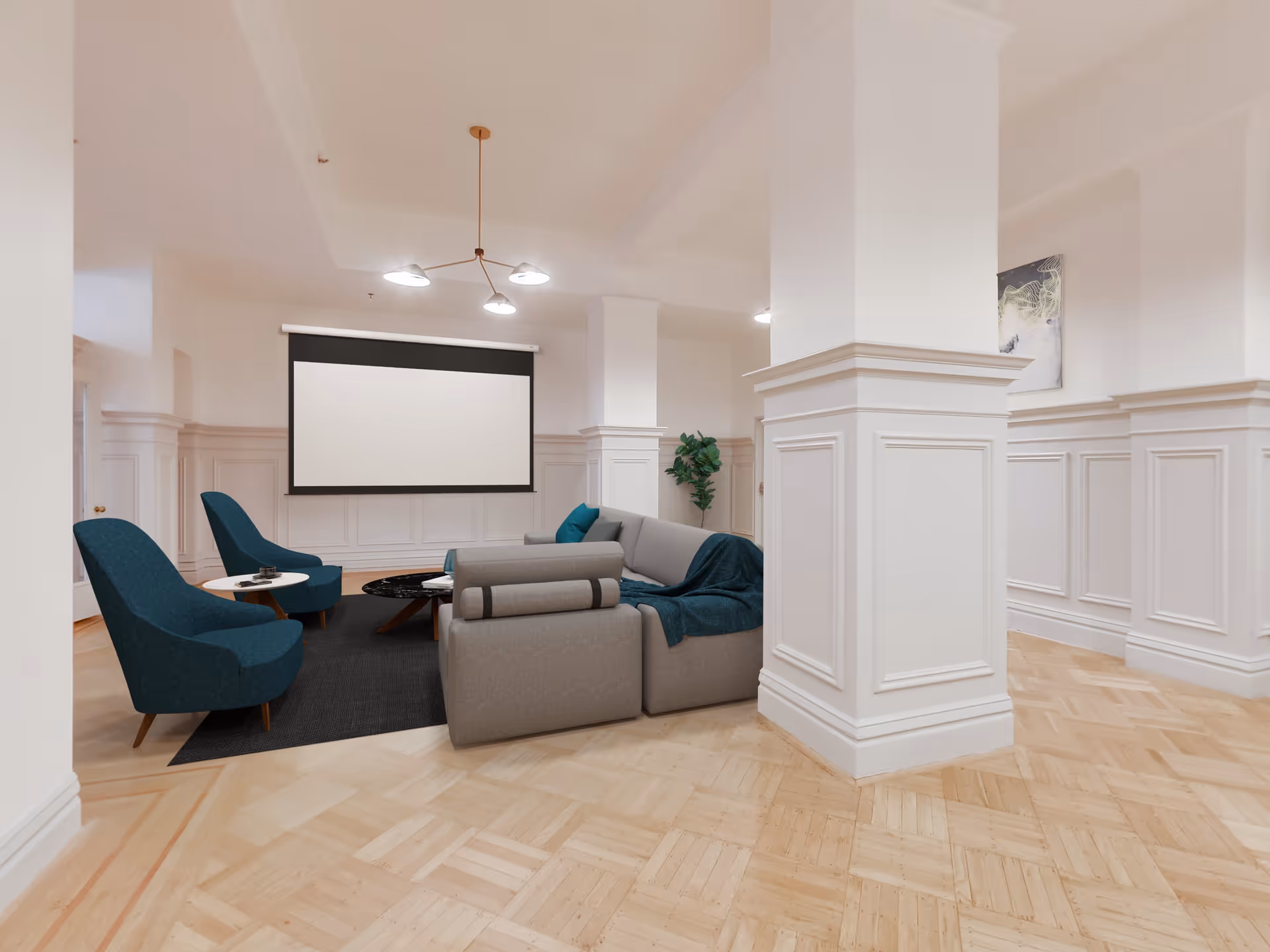 A modern lounge area with a gray sectional sofa, two blue armchairs, a black rug, and a round coffee table. The room features white paneled walls, light wood parquet flooring, a ceiling light fixture with three bulbs, and a large blank projector screen on the wall. There is also a green potted plant and a piece of abstract artwork on the wall.