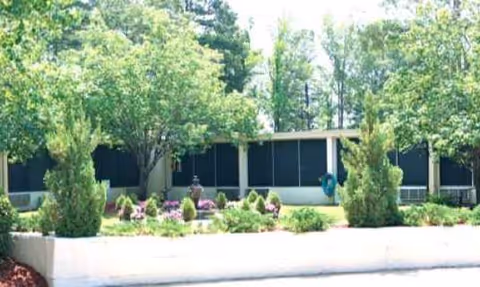 Exterior view of Brandon Nursing & Rehab Center with manicured landscaping and trees.