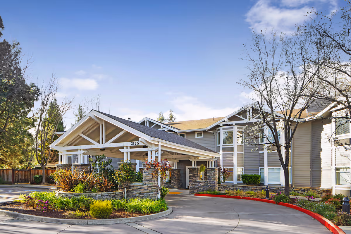 Exterior view of Ivy Park at Walnut Creek with a stone entrance and landscaped driveway.