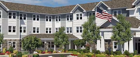 Exterior view of Brightview Tenafly senior living facility with an American flag and landscaped entrance.