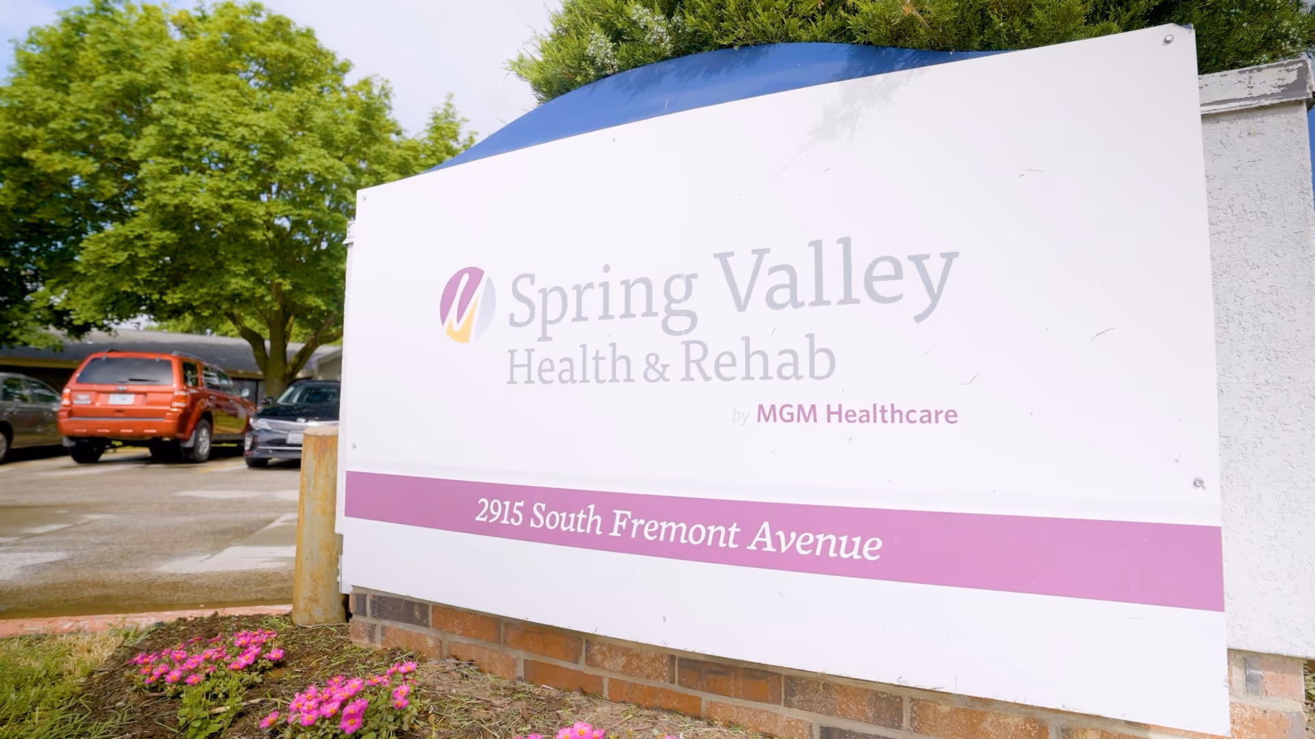 Entrance sign for Spring Valley Health & Rehab at 2915 South Fremont Avenue with parked cars and trees in the background.