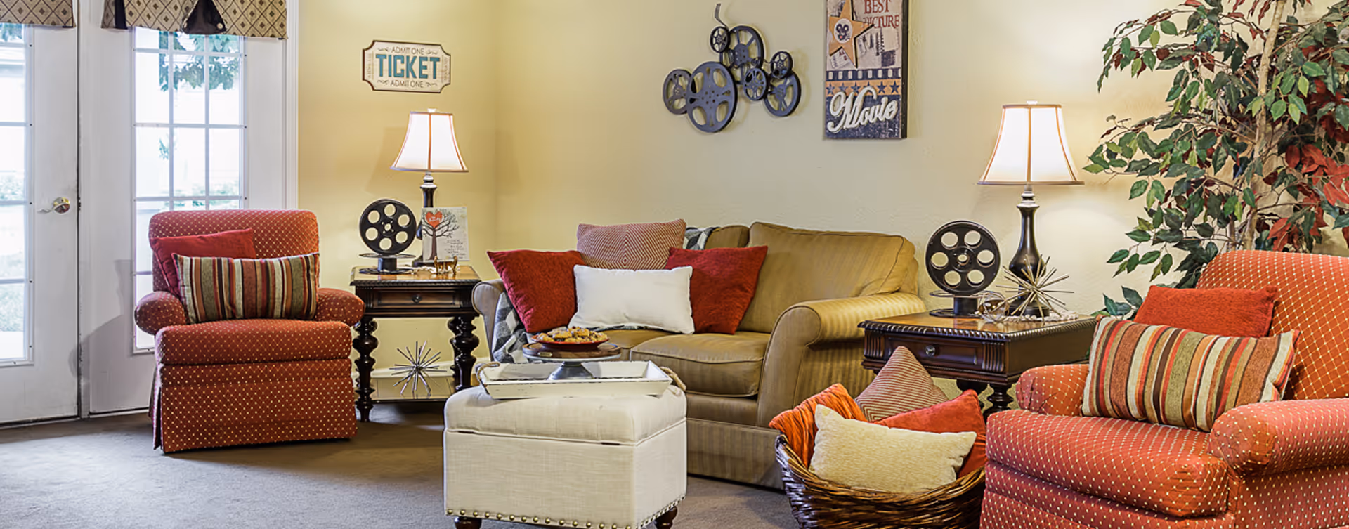 Cozy seating area with a sofa, two upholstered armchairs, an ottoman, side tables and lamps.