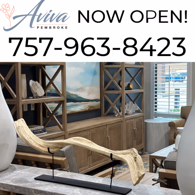 Interior sitting area with wooden shelving, artwork, and a decorative driftwood sculpture in the foreground, with a banner reading "Aviva Pembroke NOW OPEN! 757-963-8423" at the top.