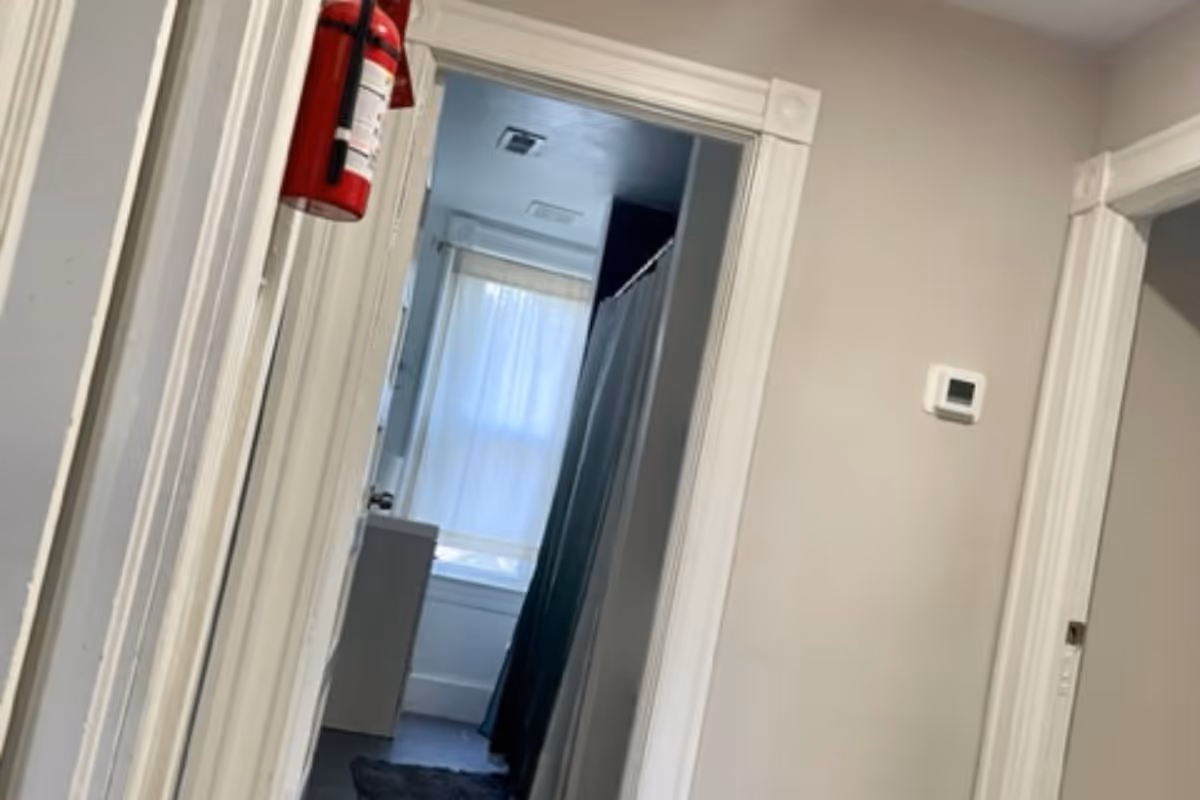 Indoor hallway leading to a bathroom in an assisted living facility.