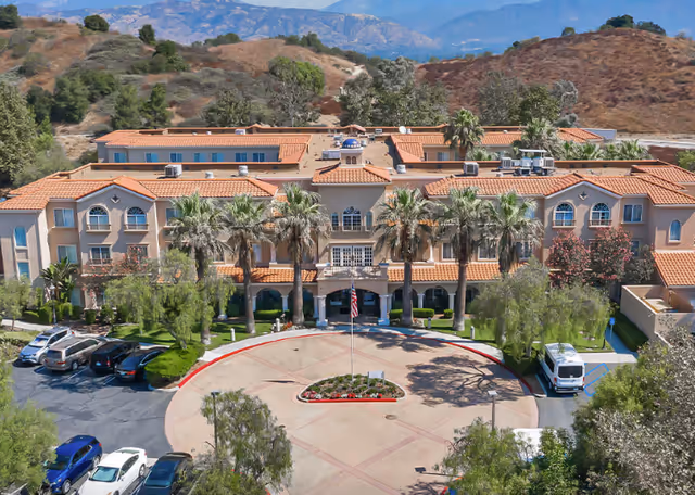 Aerial view of Bayshire San Dimas senior living center with red tile roofs and circular driveway.