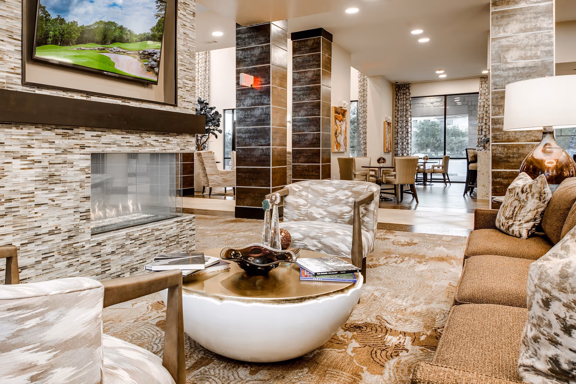 Modern communal living room/lounge with a gas fireplace, seating, coffee table and dining area visible in the background.