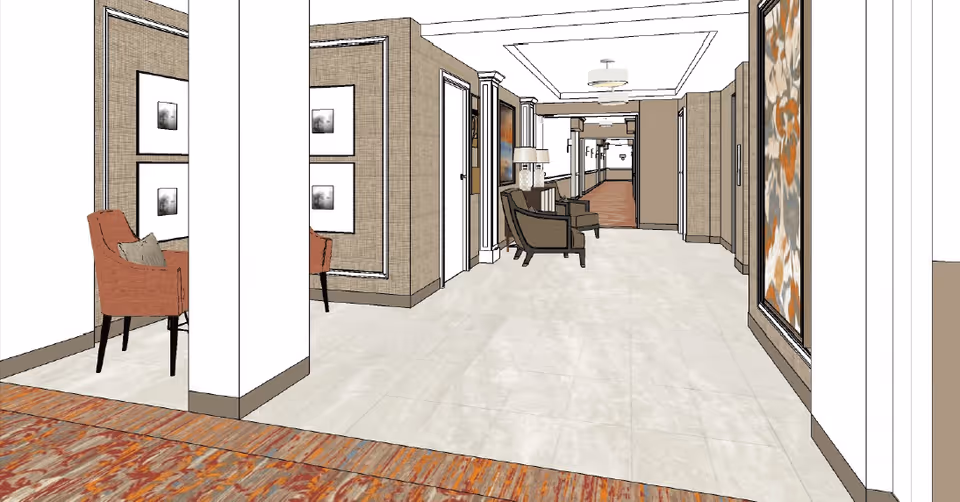 A digitally rendered interior hallway of a senior living facility with beige walls and tiled floors. The hallway features seating areas with chairs and framed artwork on the walls. The ceiling has recessed lighting and decorative molding.