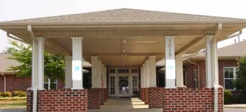 Brick building entrance with a covered portico and brick columns.