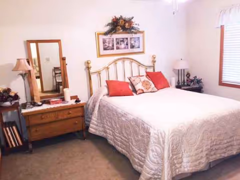 Bedroom featuring a metal bed, two nightstands, lamps, and framed photos on the wall.