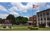 Front exterior view of Miller's Merry Manor facility with flagpole and landscaping.